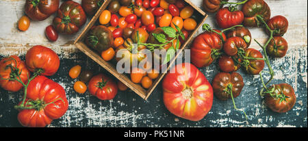 Flachbild-lay von frischen bunten reif Herbst oder Sommer Erbstück, Bund und Cherry Tomaten über rustikal Hintergrund, Ansicht von oben, horizontal Komposition. Lo Stockfoto