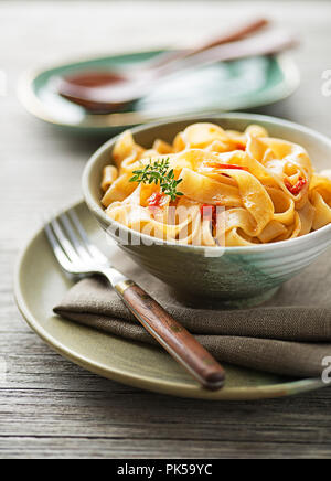 Köstliche Mahlzeit mit Pasta Bandnudeln und Tomatensauce serviert auf hölzernen Hintergrund Stockfoto