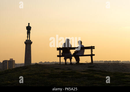 Belgrad Silhouetten in den Sonnenuntergang - zwei Frauen plaudern auf der Werkbank, mit Blick auf die Statue von Victor, Symbol der Stadt. Serbien. Stockfoto