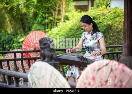 Anren, Provinz Sichuan, China - 26.August 2018: Frau spielen Guzheng traditionelle chinesische Musik Streichinstrument Stockfoto