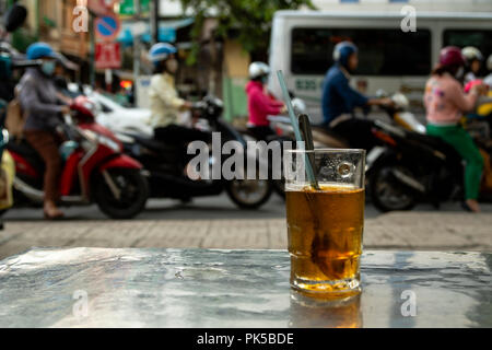 Tee trinken beobachten rush hour von Mopeds in Ho Chi Minh City Vietnam Stockfoto