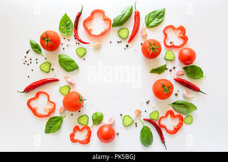 Bunter Salat Zutaten Muster aus Tomaten, Pfeffer, Chili, Knoblauch, Gurkenscheiben und Basilikum auf weißem Hintergrund. Kochen Konzept. Ansicht von oben Stockfoto