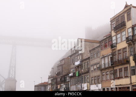 Typische Viertel von Porto in der Nähe der Brücke D Luis, von der alten mittelalterlichen Mauer mit Zinnen in einer nebligen Morgen geschützt Stockfoto