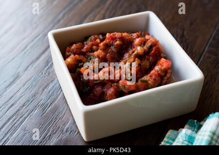 Türkisch Meze Acili acuka Ezme oder mit frischen Tomaten und Gewürze in Quadratische keramische Schüssel gemacht. Traditionelle biologische Lebensmittel. Stockfoto