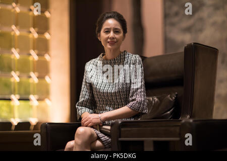 Elegante Frau sitzt auf einem Sofa Stockfoto