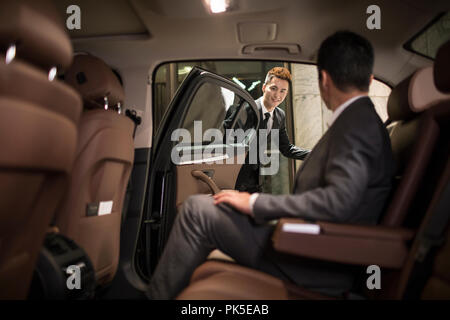 Erfolgreicher Geschäftsmann im Auto Rücksitz sitzen Stockfoto