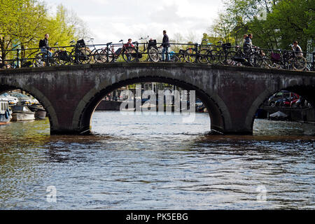 Brücken, Grachten und Fahrrädern aus einem Kanal tour Boot in Amsterdam gesehen. Amsterdam hat 500 Brücken über die Kanäle hinweg. Stockfoto