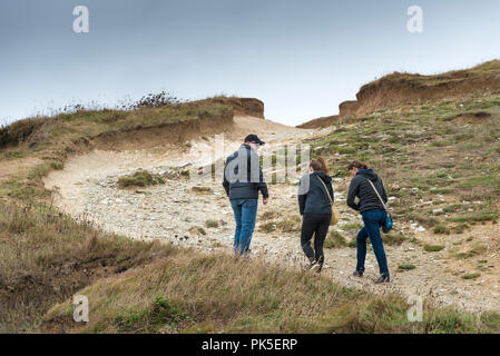 Touristen zu Fuß auf einer stark erodierten Abschnitt des South West Coast Path an der Küste von North Cornwall. Stockfoto
