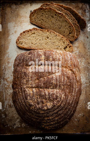 Frisches Brot auf einem rustikalen Hintergrund in Scheiben geschnitten Stockfoto