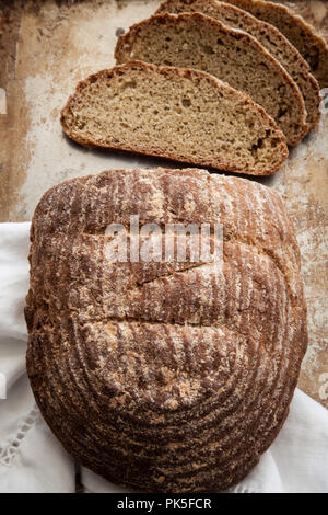 Frisches Brot auf einem rustikalen Hintergrund mit weißen Serviette in Scheiben geschnitten Stockfoto