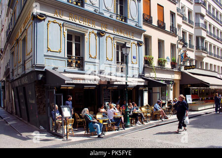 Die Menschen genießen Sie sonnige Wetter in einem traditionellen Bistro/Cafe auf einer der berühmtesten Straßen (Rue Montorgueil) in Paris. Frau vergeht. Stockfoto