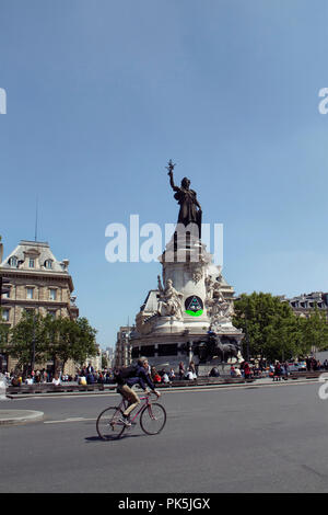 Mann fährt mit dem Fahrrad vor der Statue von Leopold Morice (1880-1952) der Platz der Republik (Place de la Republique) in Paris. Stockfoto