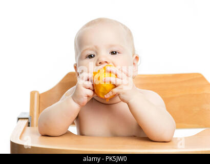Cute Baby girl peach Essen während der Sitzung in hoher Stuhl über Weiß Stockfoto
