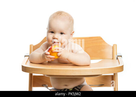 Cute Baby girl peach Essen während der Sitzung in Hochstuhl auf weißem Hintergrund Stockfoto