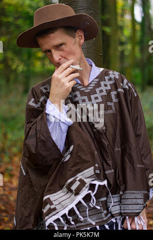 Ein Mann entspannt mit einer Zigarette in einem Waldgebiet Stockfoto