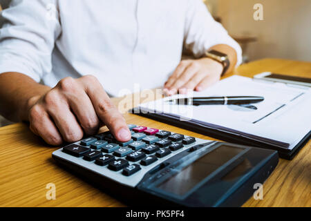 Unternehmer berechnen sie die Einnahmen aus dem Export Geschäft auf dem Holz Tisch. Business Konzept. Stockfoto