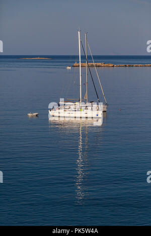 Finikas Bay: am 11. September. Zwei Segelboote in der Mitte der Bucht vor Anker, Mann schwimmen neben dem Schiff. Finikas Bay: 11. September, Syros, Griechenland Stockfoto