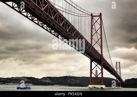 Lissabon, Portugal - Juni 1, 2018: die Ufer des Flusses Tejo in Lissabon im Frühjahr an einem bewölkten Tag. Schöne Brücke des 25. April Struktur. Stockfoto