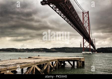 Lissabon, Portugal - Juni 1, 2018: die Ufer des Flusses Tejo in Lissabon im Frühjahr an einem bewölkten Tag. Schöne Brücke des 25. April Struktur. Stockfoto