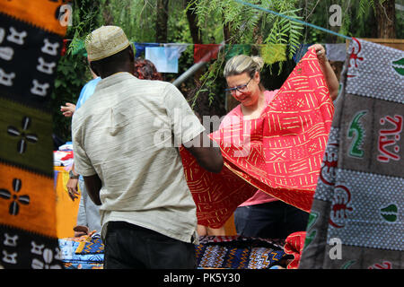 Szene der ethnische Kleidung Anbieter verkaufen Fabric auf Nachbarschaft Festival auf Poblenou, Barcelona, Spanien Stockfoto