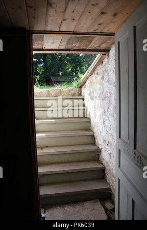 An einem Spätsommertag die Treppe hinauf und von innen aus in den Konservenkeller nach außen schauen. Stockfoto