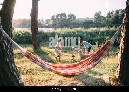 Junge sympathische Familie - Mutter, Vater und Sohn, Ruhe in der Natur, in der Nähe einer Hängematte. Stockfoto