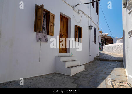 Lindos, Griechenland - August 5, 2018: Architektur des historischen Akropolis von Lindos auf der griechischen Insel Rhodos in Griechenland, mit Touristen zu Fuß aro Stockfoto