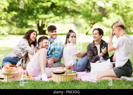 Freunde fotografieren im Sommer Picknick im Park Stockfoto