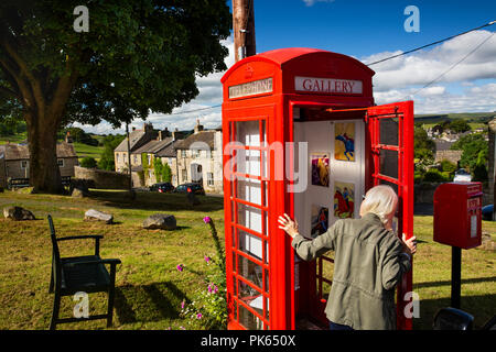 England, Yorkshire, siedeln, Grüne Kopf Lane, Besucher in die Galerie auf dem Grün suchen, in alten K6 Handy's Box, Welt smnallest Art Gallery Stockfoto