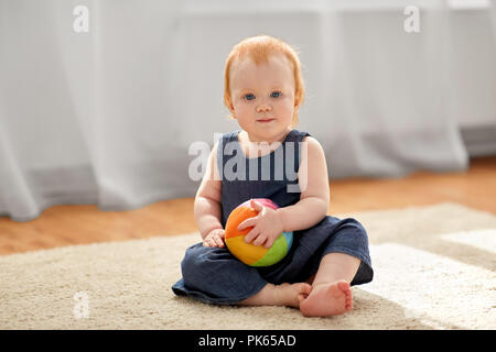 Schöne rothaarige Mädchen mit Spielzeug Ball zu Hause Stockfoto