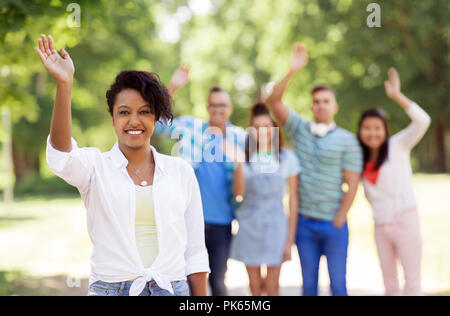 Gruppe von Happy internationale Freunde winkende Hände Stockfoto