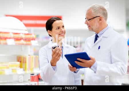 Apotheker mit Tablet Pcs und Medikament in der Apotheke Stockfoto