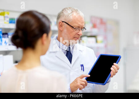 Apotheke und Kunden mit Tablet-PC in der Apotheke Stockfoto