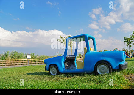 Lustige blaue Spielzeugauto auf grünem Gras Stockfoto