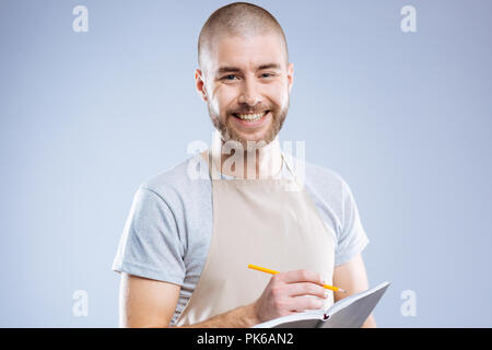 Freundliche nette Mann, bereit zu sein, sich Notizen zu machen Stockfoto