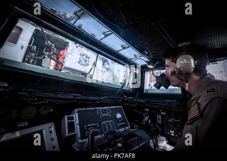 September 10, 2018 - 5. US-Flotte, USA 5 Flotte Verantwortungsbereich - 180904-N-UX 013-2043 5. US-Flotte BEREICH VON OPERATIONEN (Sept. 4, 2018) Leutnant Jonathan Marie, USS Jason Dunham (DDG109) Landung Signal Officer, steuert die Start- und Wiederherstellungsvorgänge für eine MH-60R Sea Hawk Hubschrauber, auf die "Schlangenbrut" der Hubschrauber Maritime Strike Squadron (HSM) 48, auf der das Schiff Flight Deck zugeordnet. Dunham ist in die USA 5 Flotte Bereich der Maßnahmen zur Unterstützung der Marine im Einsatz für die Stabilität und Sicherheit in der Region zu gewährleisten und verbindet das Mittelmeer und die Pac Stockfoto