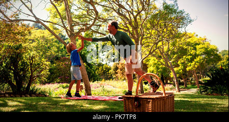 Vater und Sohn eine hohe fünf beim Picknick Stockfoto