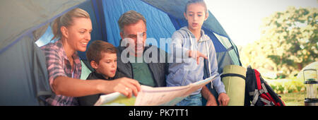 Familie Lesen der Karte im Zelt Stockfoto