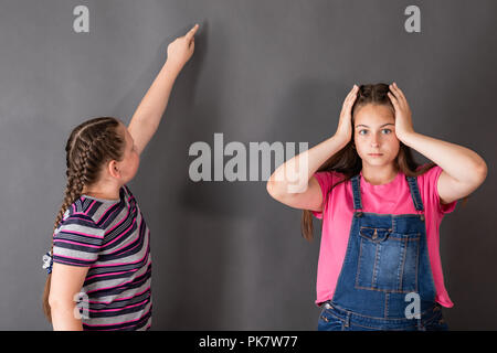 Ein Mädchen ist überrascht, wie leicht und schön die anderen die Aufgabe löst. Freien Speicherplatz für Ihre Themen Stockfoto