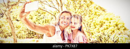 Mutter und Tochter unter selfie auf Handy im Park Stockfoto