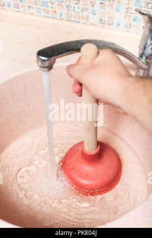 Man löscht Spüle ablaufen, indem Sie die Gummistopfen Stockfoto