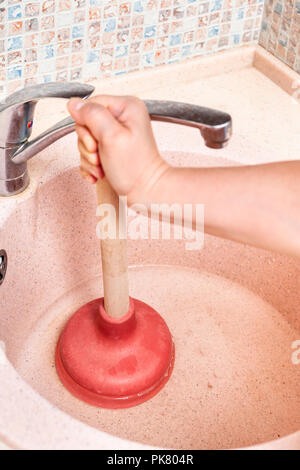 Frau löscht Spüle ablaufen, indem Sie die Gummistopfen Stockfoto