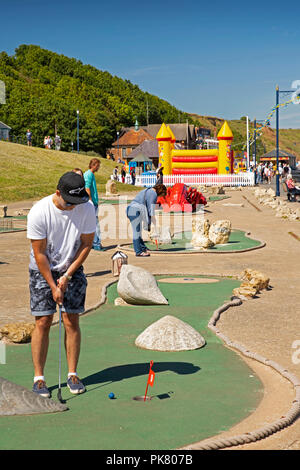 Vereinigtes Königreich, England, Yorkshire, Filey, Promenade, Erwachsene spielen Crazy Golf im Sunshine Stockfoto