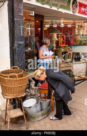 Vereinigtes Königreich, England, Yorkshire, Filey, Murray Street, Kunden an Antiquitäten angezeigt außerhalb des Shops auf Bürgersteig auf der Suche Stockfoto