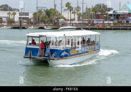 John's Pass Village an touristische Lage nahe Madeir Beach, Florida, USA. Eine touristische Fähre nähert sich dem Kai Stockfoto