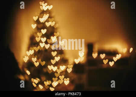 Weihnachten Abstract Background, schöne Weihnachtsbaum Golden Lights Herz bokeh. Unschärfe der gelb leuchtenden Beleuchtung im festlichen Zimmer. Die Einrichtung für Win Stockfoto