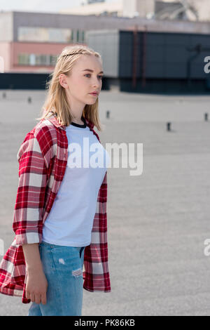 Stilvolle Teen Girl in Red Plaid Shirt auf der Dachterrasse Stockfoto