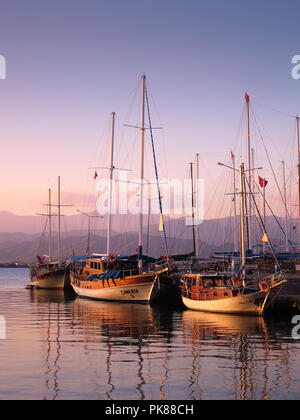 Sonnenuntergang in Fethiye mit traditionellen ziemlich touristische Gulet Boote in ruhigem Wasser verankert Stockfoto