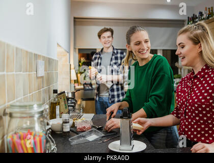Freunde sind das Vorbereiten der Nahrung für eine Dinner Party zu Hause. Stockfoto