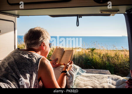 Lady lesen in einem Wohnmobil an Newgale St Brides Bay Haverfordwest Pembrokeshire Wales Stockfoto